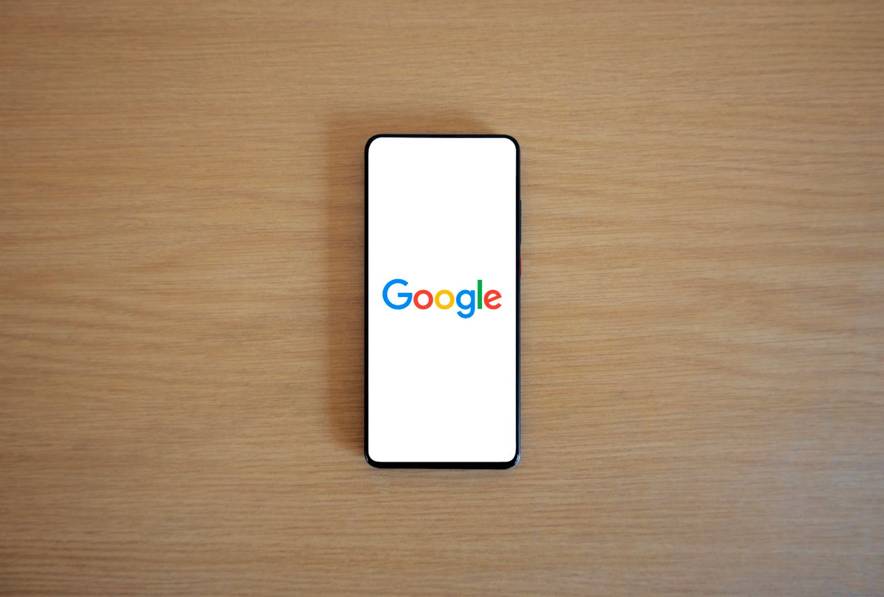 services-03 Un smartphone affichant la page d’accueil de Google sur une surface en bois, vu de dessus.